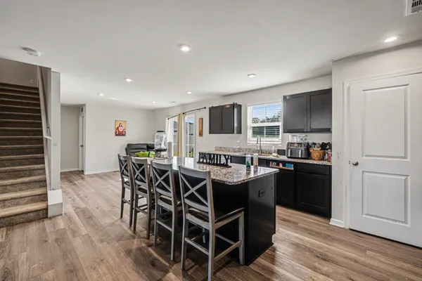 a dining hall with stainless steel appliances granite countertop a stove and a refrigerator
