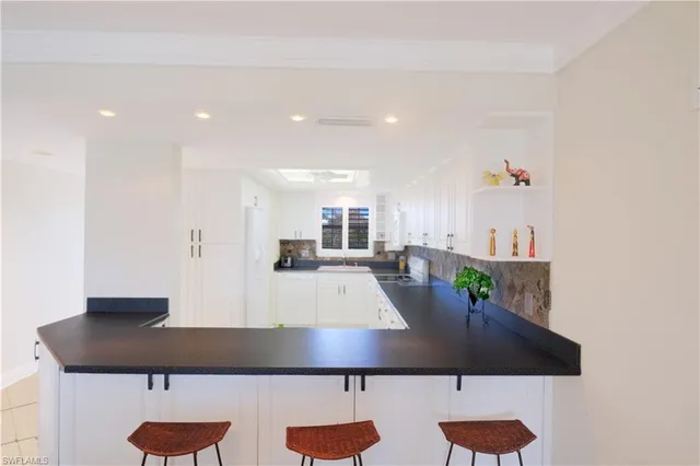 a large kitchen with stainless steel appliances granite countertop a sink a stove and a refrigerator