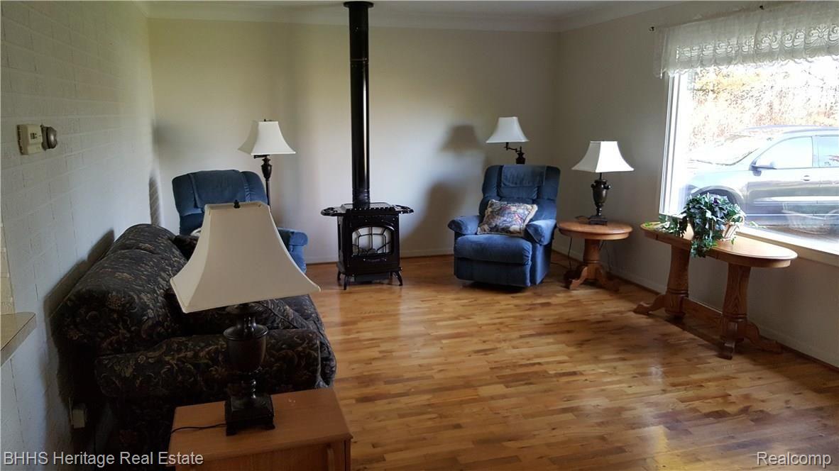 85 South Truhn Road Fowlerville, MI 48836 - Photo 2 of 14 Living room with hardwood floors and gas stove