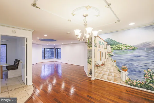 a view of a room with wooden floor and chandelier