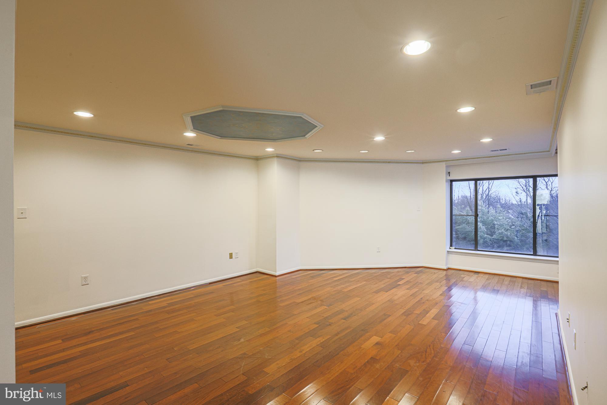 3041 Fallstaff Road, Unit 405D Baltimore, MD 21209 - Photo 18 of 38 an empty room with wooden floor and windows