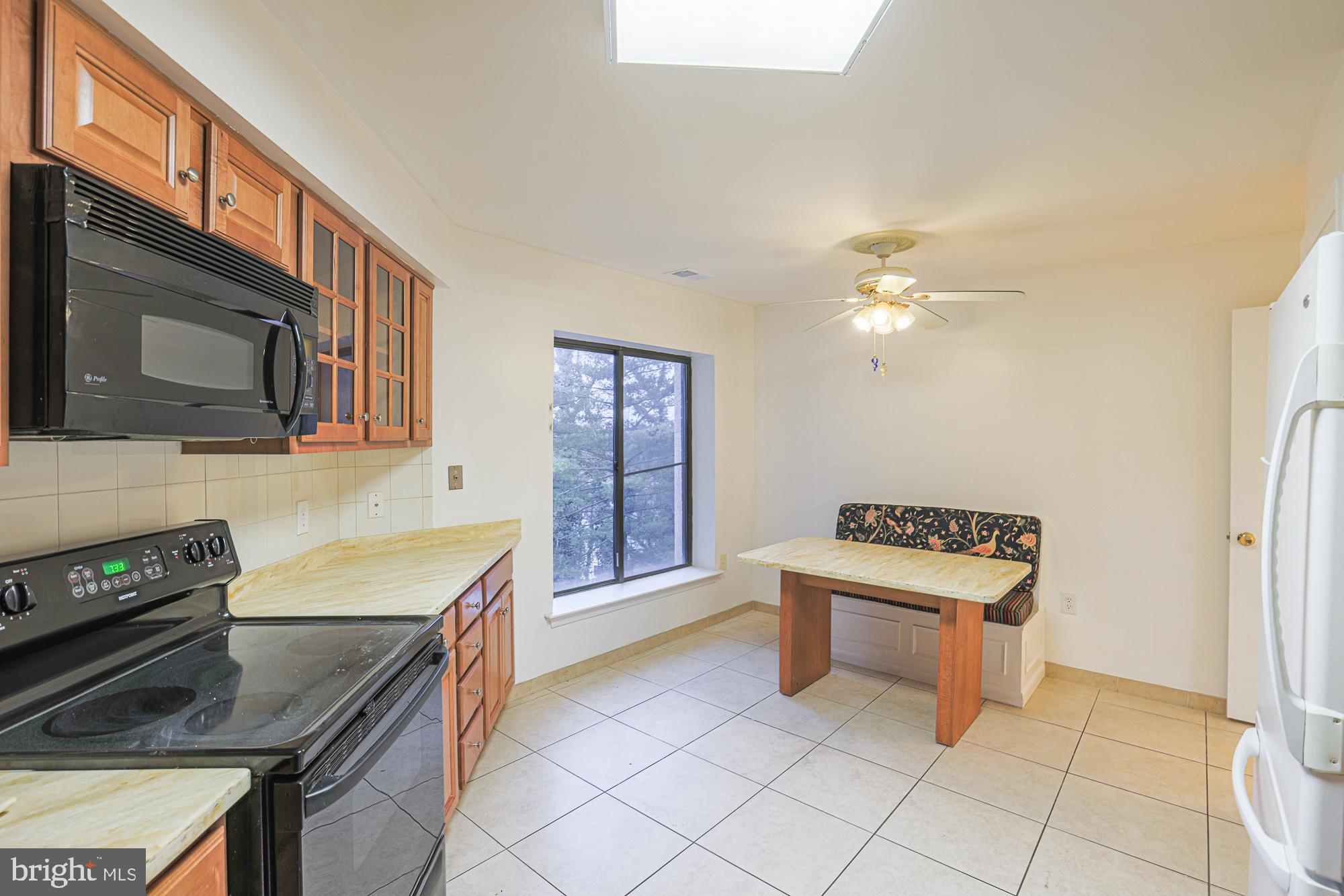 3041 Fallstaff Road, Unit 405D Baltimore, MD 21209 - Photo 23 of 38 a kitchen with stainless steel appliances granite countertop a stove a sink and a microwave