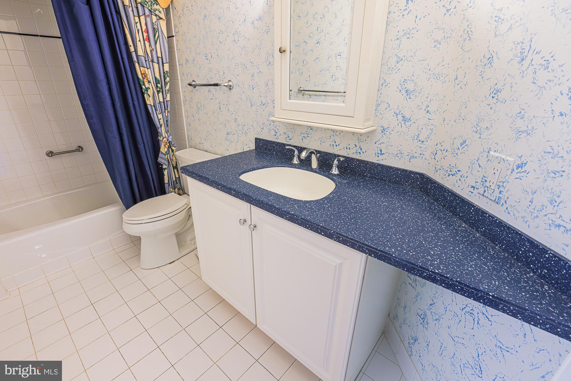 3041 Fallstaff Road, Unit 405D Baltimore, MD 21209 - Photo 26 of 38 a bathroom with a granite countertop sink and a mirror