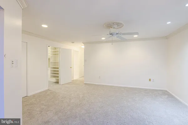 an empty room with a glass door and chandelier