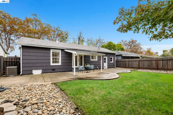 a backyard of a house with garden and outdoor seating
