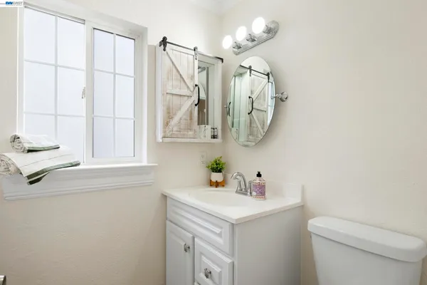 a bathroom with a sink a toilet and mirror