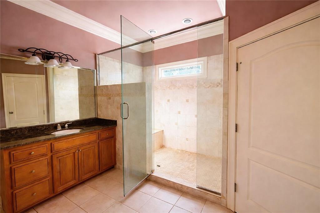 3930 Demooney Road Atlanta, GA 30349 - Photo 16 of 36 a bathroom with a granite countertop shower a mirror and a sink
