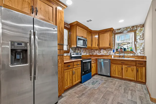 a kitchen with stainless steel appliances granite countertop a refrigerator and a stove top oven