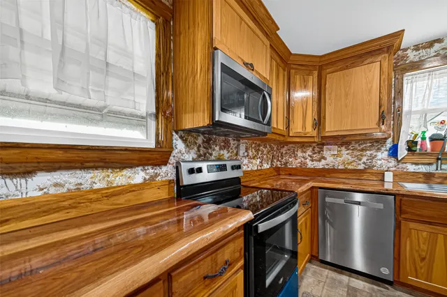 a kitchen with stainless steel appliances granite countertop a sink stove and microwave