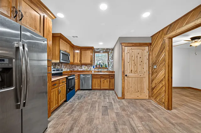 a kitchen with stainless steel appliances a refrigerator and a stove top oven