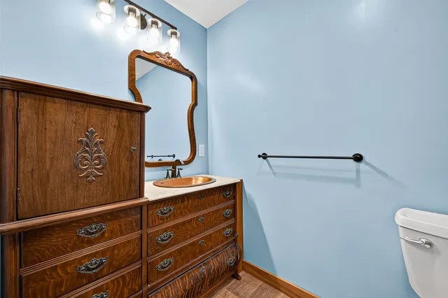 a bathroom with a sink and mirror with toilet