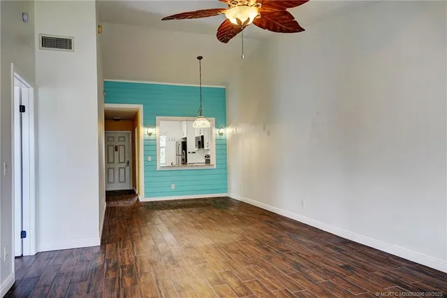 a view of a room with wooden floor fan and a window