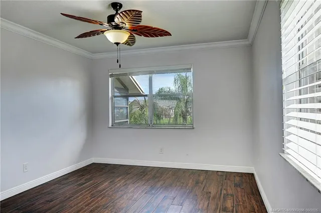 a view of room with window ceiling fan and hardwood floor