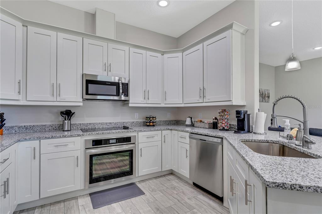 2201 Abalone Boulevard Orlando, FL 32833 - Photo 13 of 32 a kitchen with granite countertop a sink stainless steel appliances and cabinets