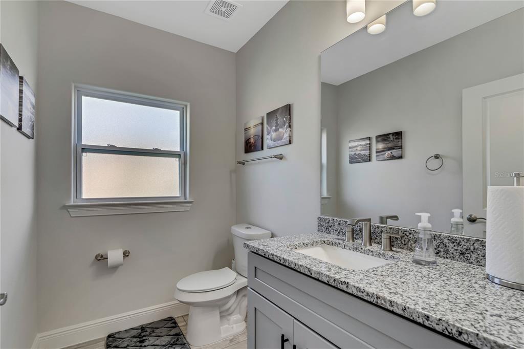 2201 Abalone Boulevard Orlando, FL 32833 - Photo 19 of 32 a bathroom with a granite countertop sink a toilet and a mirror