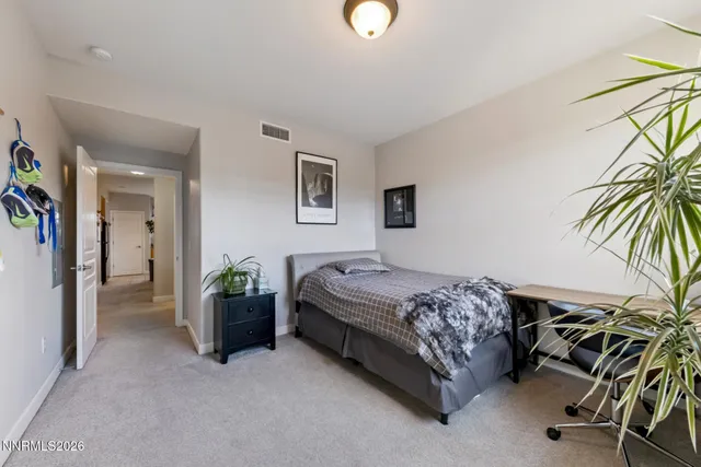 a bedroom with a bed and a potted plant