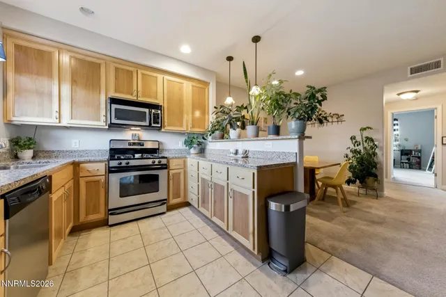 a kitchen with stainless steel appliances granite countertop a stove a sink and a microwave