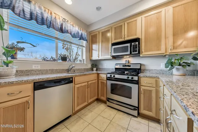 a kitchen with stainless steel appliances granite countertop a sink stove and cabinets