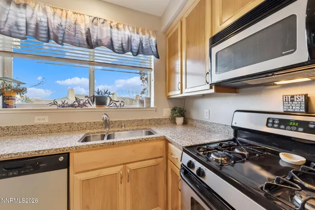 a kitchen with stainless steel appliances granite countertop a stove and a microwave