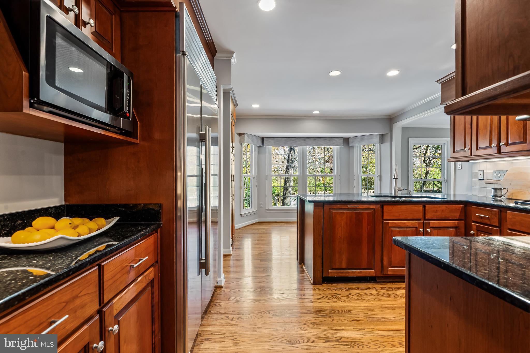 2716 Glencroft Road Vienna, VA 22181 - Photo 18 of 66 a kitchen with stainless steel appliances granite countertop a refrigerator a stove and a microwave with wooden floor