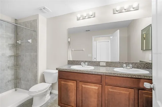 a bathroom with a granite countertop sink toilet and shower