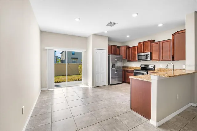 a kitchen with stainless steel appliances granite countertop a refrigerator and a stove top oven