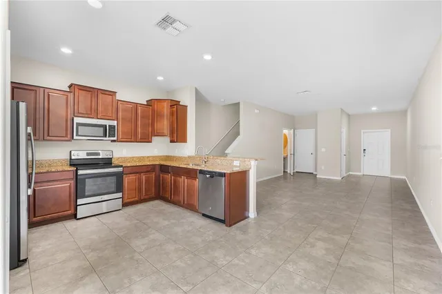 a large kitchen with a large counter top appliances and cabinets