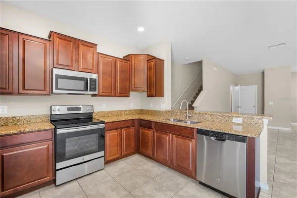 a kitchen with stainless steel appliances granite countertop wooden cabinets microwave and stove