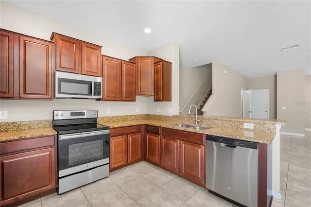 a kitchen with stainless steel appliances granite countertop wooden cabinets microwave and stove
