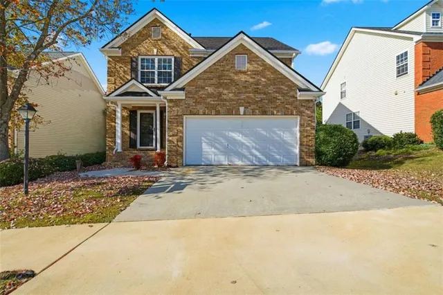 a front view of a house with a garden and garage