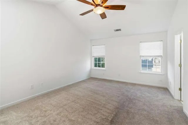 an empty room with a window and a fan