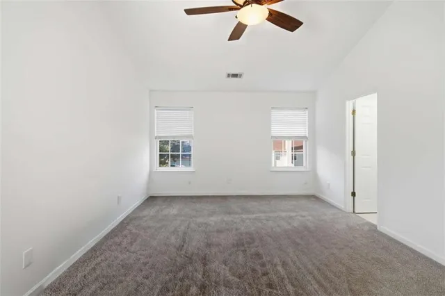 an empty room with a window and a ceiling fan