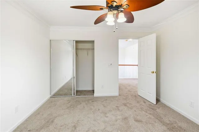 an empty room with closet and a chandelier fan