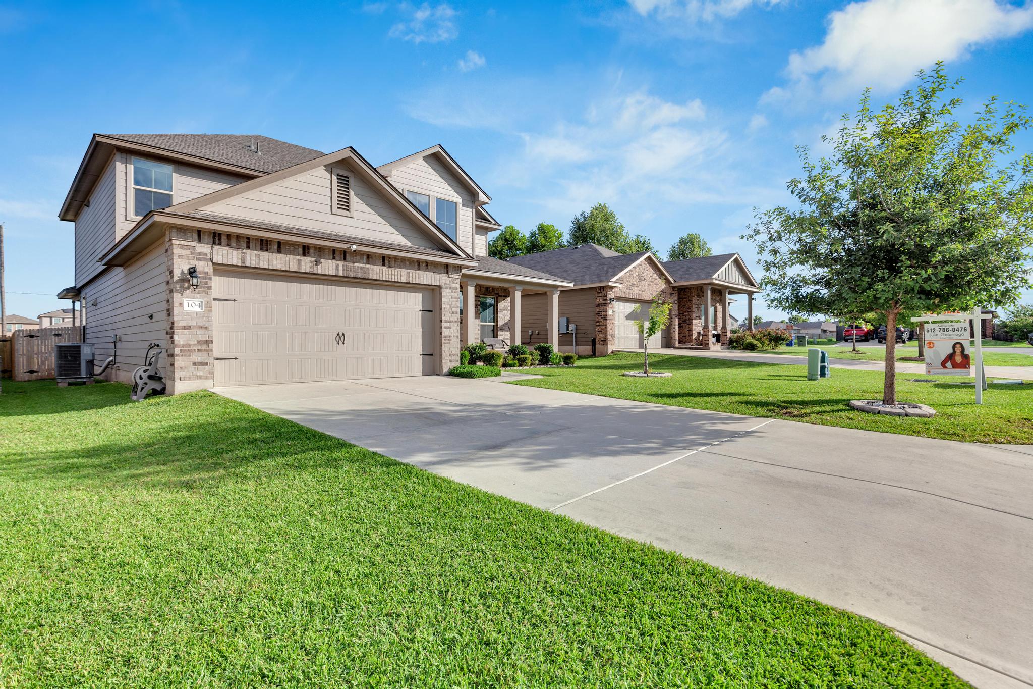 104 Uncle Billy Way Jarrell, TX 76537 - Photo 2 of 38 A classic two-story residence with an integrated garage and manicured front lawn.