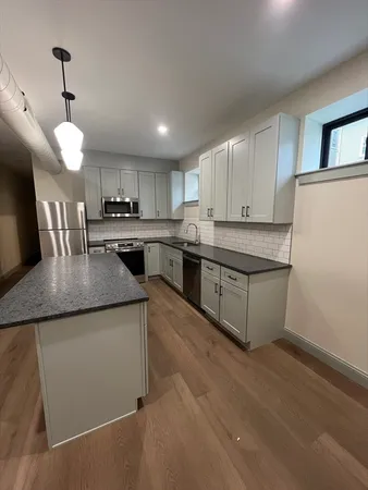 a kitchen with stainless steel appliances granite countertop a sink a stove top oven a counter space and cabinets