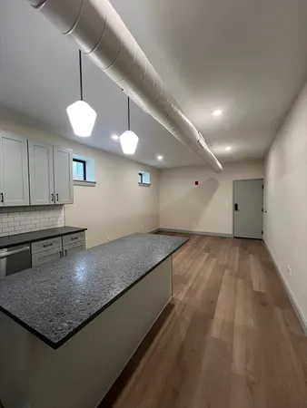a kitchen with a center island and wooden floor