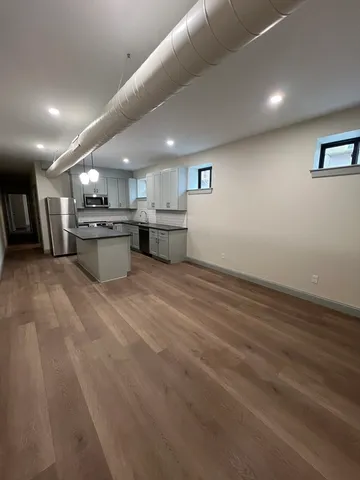 a large kitchen with stainless steel appliances a large counter top