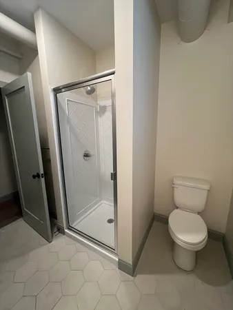 a bathroom with a toilet and a shower