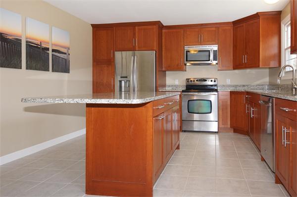 412 George Hill Road Lancaster, MA 01523 - Photo 7 of 26 a kitchen with stainless steel appliances granite countertop a refrigerator and a stove top oven