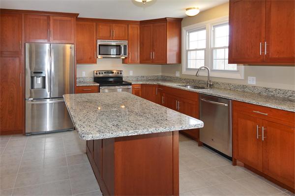 412 George Hill Road Lancaster, MA 01523 - Photo 8 of 26 a kitchen with stainless steel appliances granite countertop a refrigerator a sink a stove a microwave and wooden cabinets