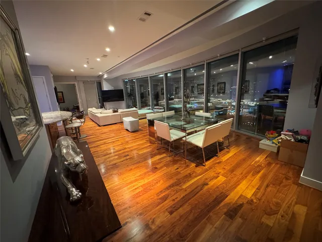 a living room with furniture hard wood floor and kitchen view