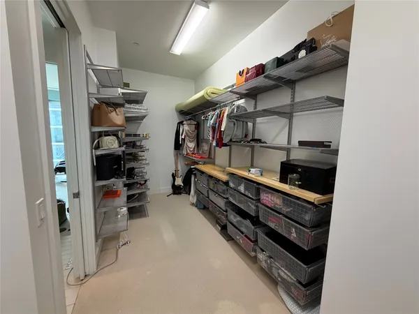 a view of walk in closet with clothes and shoes