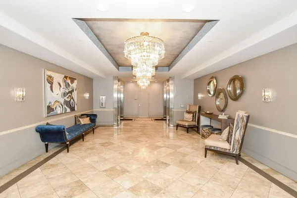 a living room with furniture a chandelier and a rug