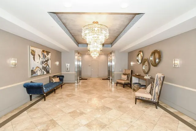 a living room with furniture a chandelier and a rug