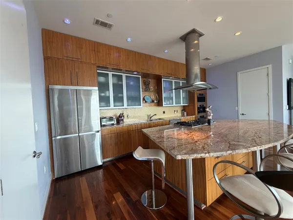 a kitchen with stainless steel appliances granite countertop a stove refrigerator and cabinets