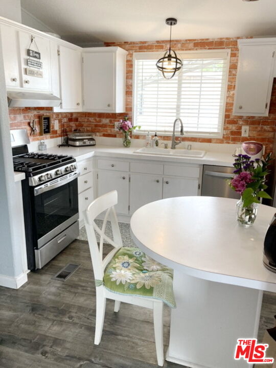 1051 Site Drive, Unit 209 Brea, CA 92821 - Photo 9 of 18 a kitchen with a table chairs stove and cabinets