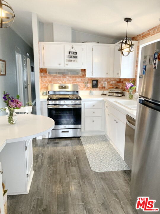 1051 Site Drive, Unit 209 Brea, CA 92821 - Photo 10 of 18 a kitchen with kitchen island a stove a sink dishwasher and a refrigerator