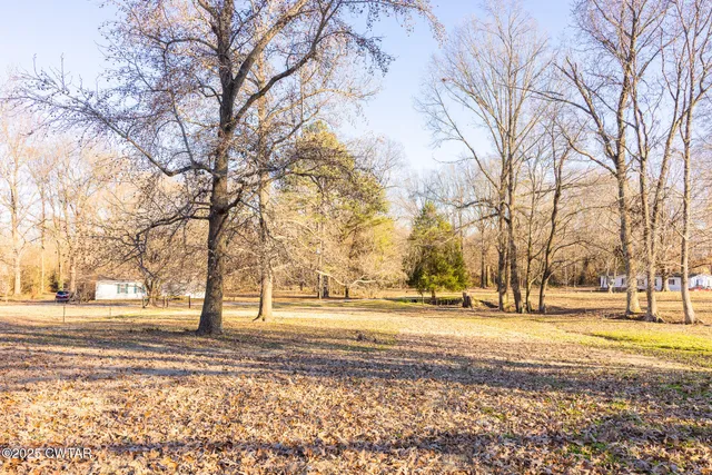 a view of a yard with wooden fence