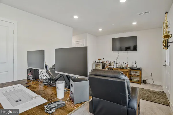 a view of a workspace with furniture and a flat screen tv