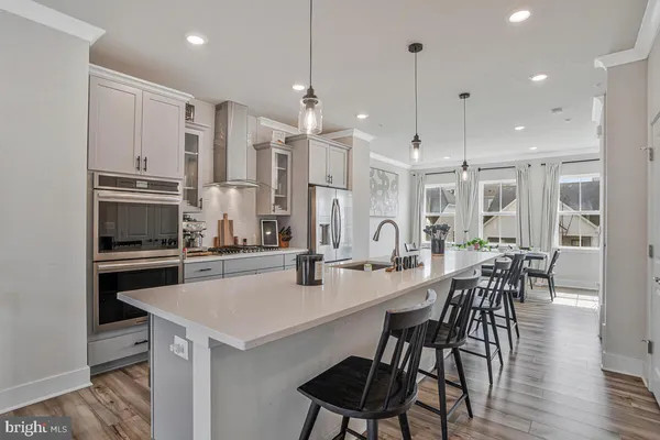 a kitchen with granite countertop a table chairs microwave and cabinets